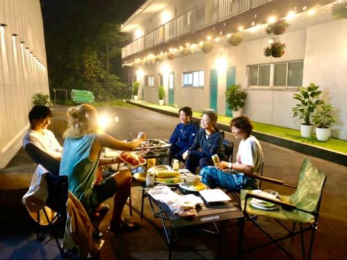 a group of people sitting at a table with food at FujiteraCanvas102 in Gotemba