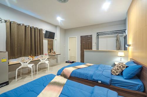 a bedroom with two beds and a table and chairs at Penyos Residences in Bangkok