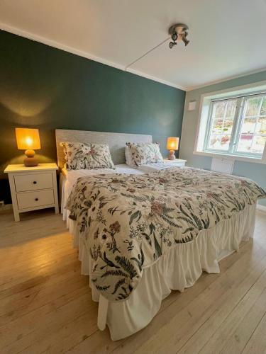 a bedroom with a large bed and two night stands at Stryn - house by the river in Stryn