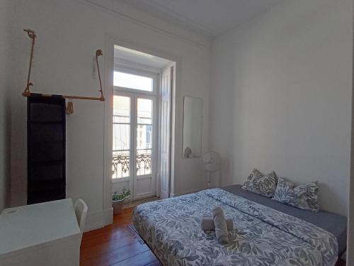 a bedroom with a bed with a pair of shoes on it at Embassy Arriaga Private Elegance Rooms in Stylish Shared Apartment in Lisbon