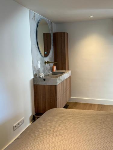 a bedroom with a sink and a mirror at Homes by the C in Zandvoort