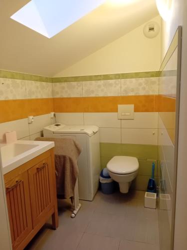 a small bathroom with a toilet and a sink at Villa des écureuils in Dole