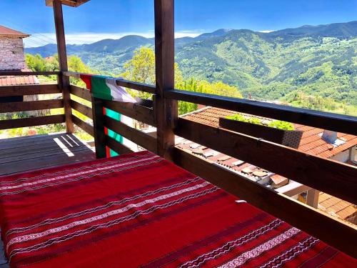 a bench on a balcony with a view of mountains at Paradise - Guest House in Beden