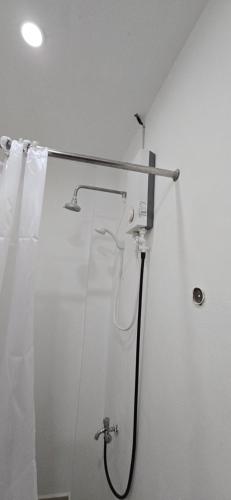 a shower in a bathroom with a shower curtain at Calamianes Homestay in Coron