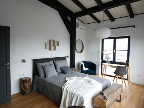 a bedroom with a large bed and a chair at The Pines Boutique Villa in Braşov