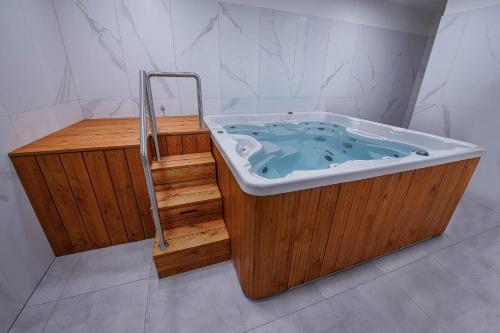 a wooden bath tub with a wooden stairs in a bathroom at Hotel Villa in Prague