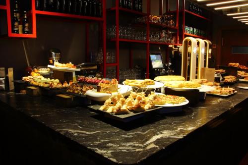 a buffet with many different types of food on a counter at Poshtel Bilbao - Premium Hostel in Bilbao