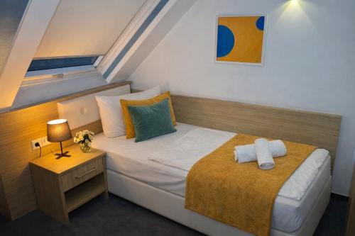 a small bedroom with a bed and a night stand at Alpha & Omega Hotel Stuttgart - air-conditioned in Stuttgart