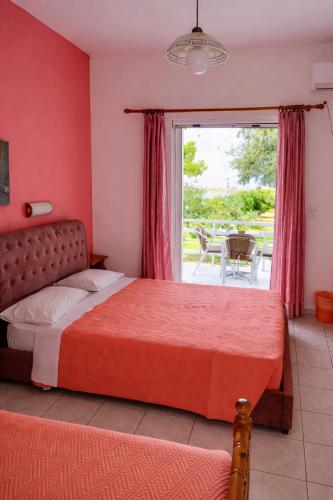 a bedroom with a bed and a window with a patio at Stelios Studios - Zante Seaview Nests in Tragaki