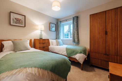 a bedroom with two beds and a window at The Stables in Huntingdon