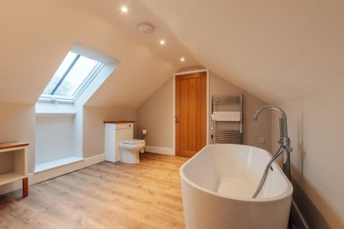 a bathroom with a bath tub in a attic at The Stables in Huntingdon