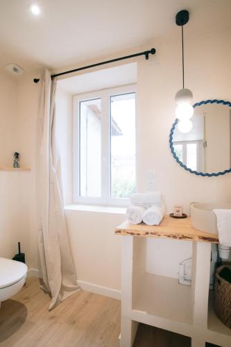 a bathroom with a sink and a toilet and a window at Les archives de Georges 153 - Appart' de standing en centre-ville - Balcon privé, Climatisation, Caméra de vidéo surveillance in Périgueux