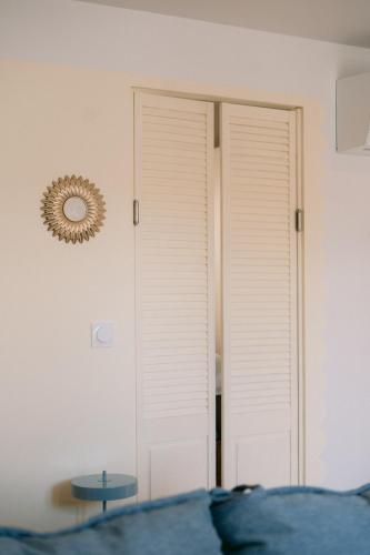 a door in a bedroom with a table and a mirror at Les archives de Georges 153 - Appart' de standing en centre-ville - Balcon privé, Climatisation, Caméra de vidéo surveillance in Périgueux