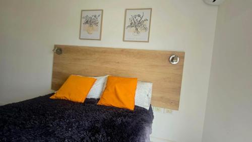 a bed with a wooden headboard and two pillows at Departamento centro in Paraná
