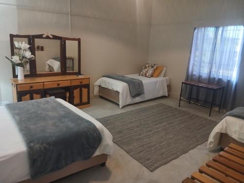 a bedroom with two beds and a mirror at Vastrap Guest Farm in Grünau