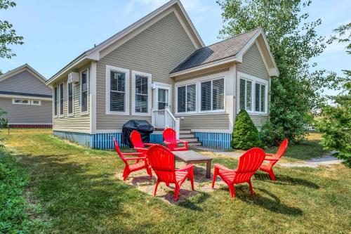 a group of red chairs and a table in front of a house at The Bluebird - 34 Meadow View in Cherry Valley