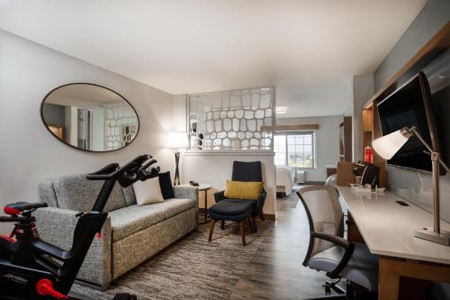 a living room with a couch and a mirror at EVEN Hotels Denver Tech Center-Englewood by IHG in Centennial