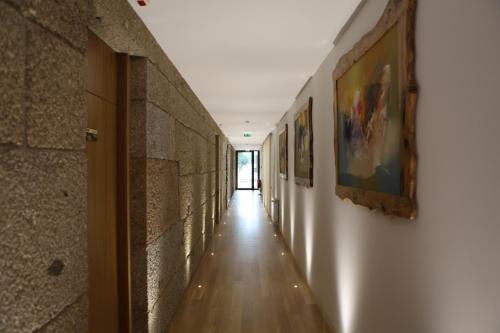 a hallway with paintings on the walls of a building at Hotel Rural Quinta das Quintães in Penafiel