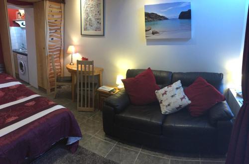 a living room with a couch and a bed at Artisan Studio in Tarbert