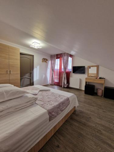 a large bedroom with two beds and a window at Popasul Ursului Zărnești in Zărneşti