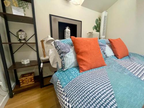 a bedroom with a bed with orange and blue pillows at Appartamento - Mini Suite in Brescia