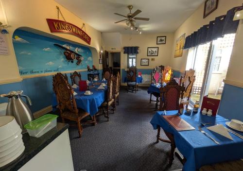 a dining room with blue tables and chairs in a restaurant at Kingswinford Guest House with Free Parking in Paignton