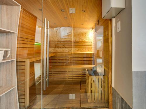 a walk in shower in a room with wooden ceilings at Villa with jacuzzi & sauna 500m from beach in Middelkerke