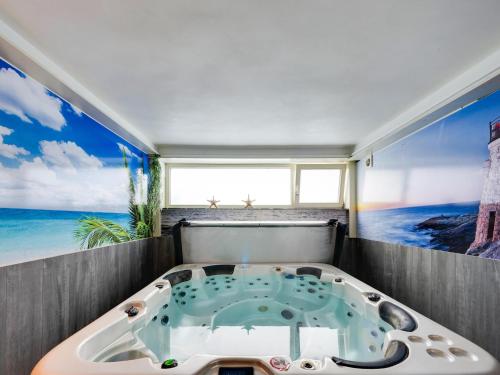 a bath tub with a view of the ocean at Villa with jacuzzi & sauna 500m from beach in Middelkerke