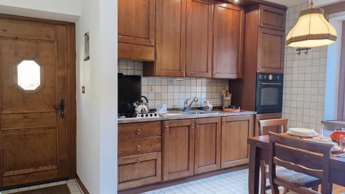 a kitchen with wooden cabinets and a sink at Casa Savilla by Ca-Sa Check in Pieve di Cadore