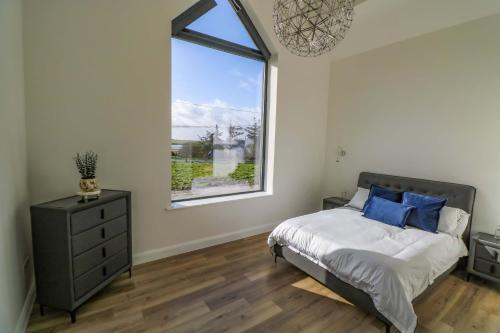 a bedroom with a bed and a large window at An Tobar in Ballina