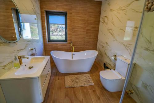 a bathroom with a tub and a toilet and a sink at An Tobar in Ballina