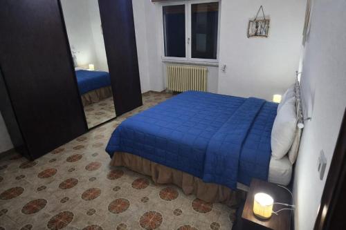 a bedroom with a blue bed and a mirror at "Babbo" Nicola in Salve