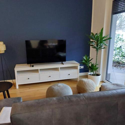 a living room with a couch and a flat screen tv at Gemütlich wohnen nahe Frankfurt in Karben