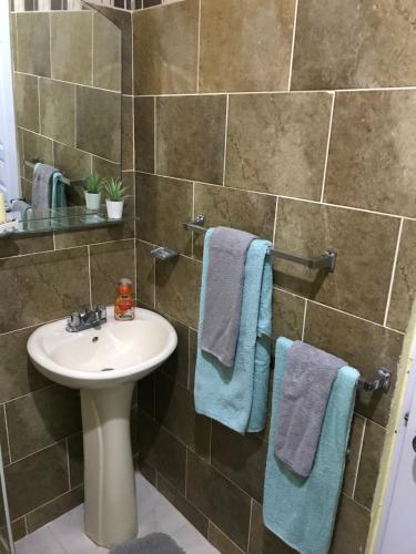 a bathroom with a sink and blue towels at Independent, central studio Apt3-A in El Seis