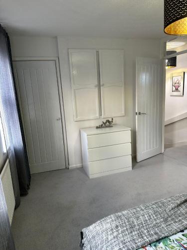 a bedroom with a bed and a dresser and a door at 2 Millway in Golden Valley