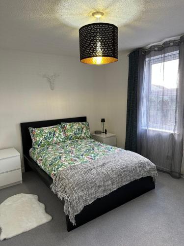 a bedroom with a bed and a chandelier at 2 Millway in Golden Valley