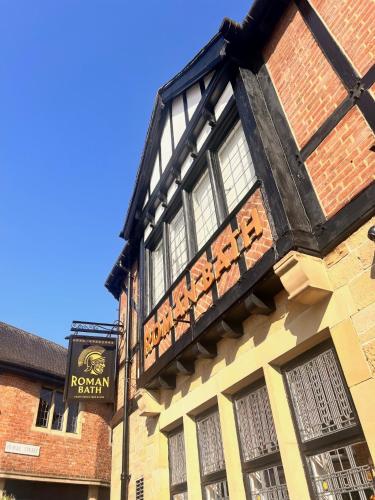 a building with a sign on the side of it at The Roman Bath in York