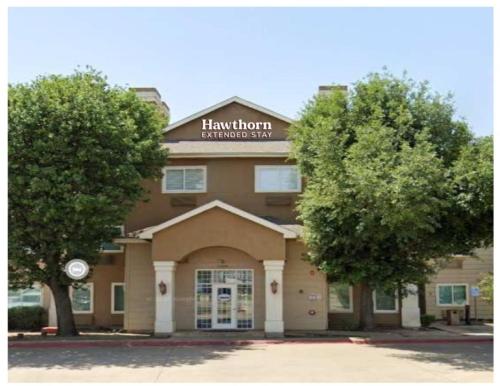 a building with a sign on top of it at Hawthorn Extended Stay by Wyndham Lewisville in Lewisville