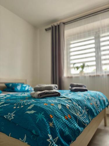 a bedroom with a bed with a blue comforter at Apartmán U Štýbnarů in Bulhary