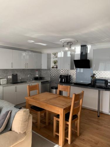 a kitchen and dining room with a wooden table at Crayford's Guest House in Aberdeen