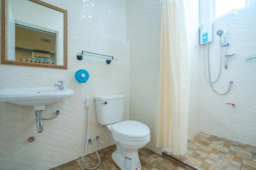 a bathroom with a toilet and a sink and a shower at Penyos Residences in Bangkok
