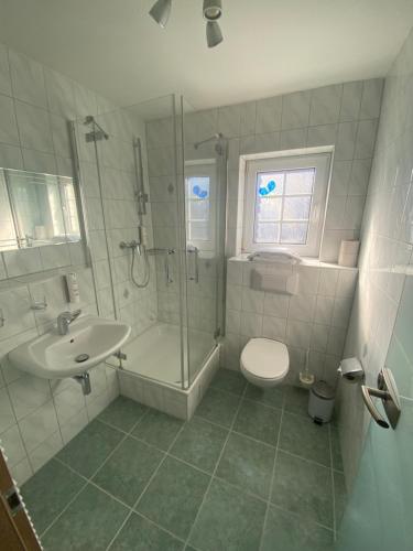 a bathroom with a shower and a toilet and a sink at Hotel Falkenseer Hof in Falkensee