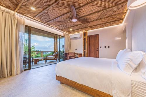 a bedroom with a bed and a balcony at Tiki Villas Rainforest Lodge - Adults Only in Uvita