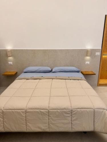 a bedroom with a large bed with blue pillows at L'Atrio Suite in Torre del Greco