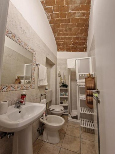 a white bathroom with a sink and a toilet at Gioberti in Casale Monferrato