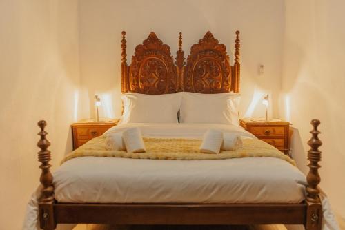 a bedroom with a large bed with a wooden headboard at Refúgio da Cancela - Arouca Stay in Arouca
