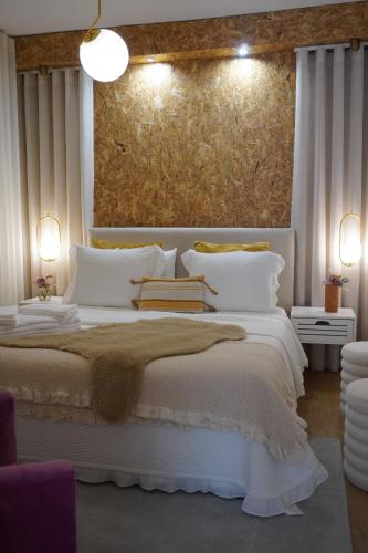 a bedroom with a white bed with a painting on the wall at Casa das Caldas in Caldelas