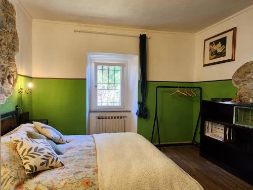 a green bedroom with a bed and a window at Limone e Peperoncino B&B in Mulazzo