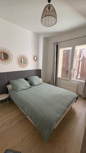 a bedroom with a large bed with a green comforter at JMAM Urban Suite T2 Climatisé en centre ville proche plage in Fos-sur-Mer
