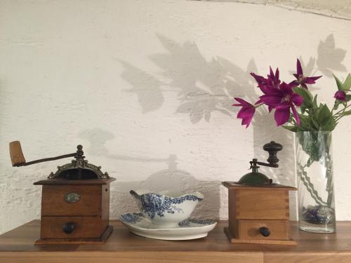 ein Holzregal mit einer Blumenvase und einer Vase in der Unterkunft The Charterhouse in Torquay